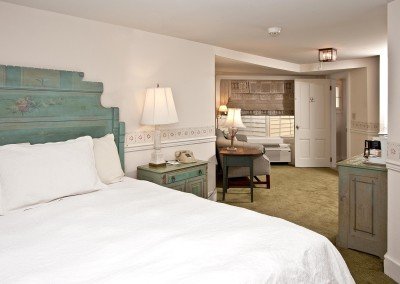White bed with aqua headboard and geometrically shaped room