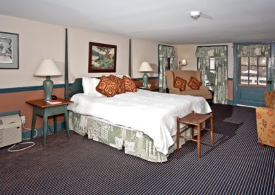 Room with white antique bed and striped carpet