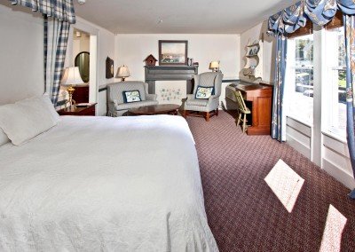 Room with red carpet, windows, desk and antique furniture